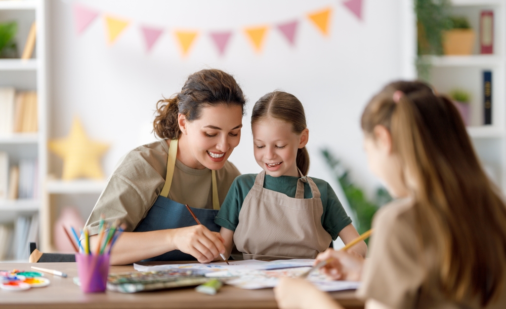 Mutter und Tochter malen gemeinsam am Tisch