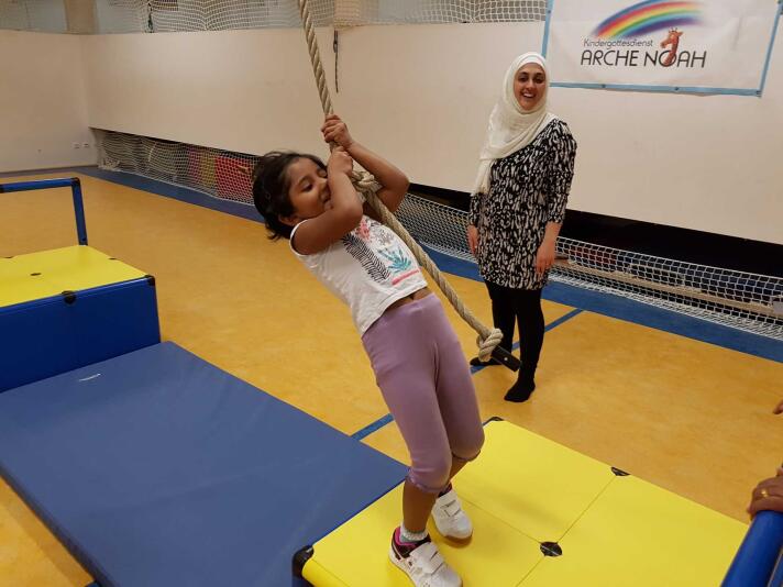 Kleinkinder beim Bewegungsspiel im Kreis in einer Turnhalle